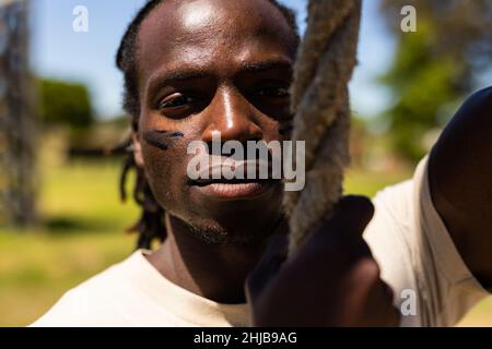 Porträt eines afroamerikanischen Soldaten, der ein Seil im Boot-Camp hält Stockfoto