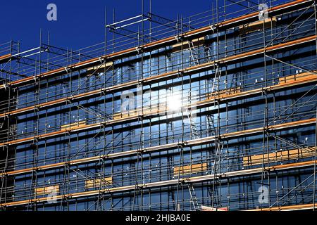 München, Deutschland. 27th Januar 2022. Große Baustelle, Baustelle, Rohbau, Bau einer Schule, Schulzentrum im Stadtteil Messestadt Riem in München. Geruest, Baugerüst, die Sonne spiegelt sich in den bereits installierten Fenstern wider. Bauindustrie, Neubau, Gebäude, Komplex, Immobilien, Wohnbau, Mietwohnung, Miete, Bauboom, Mehrfamilienhaus, Fassade, Bau, Bau, Bau, Immobilien, Bau, Metropolregion Stadt. Kredit: dpa/Alamy Live Nachrichten Stockfoto