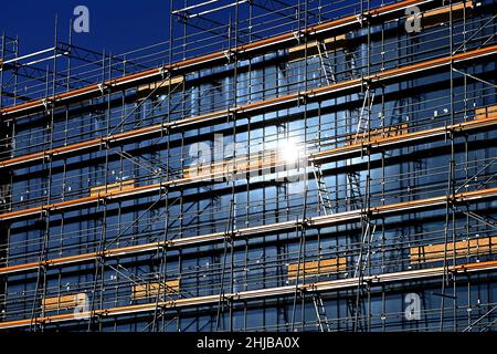 München, Deutschland. 27th Januar 2022. Große Baustelle, Baustelle, Rohbau, Bau einer Schule, Schulzentrum im Stadtteil Messestadt Riem in München. Geruest, Baugerüst, die Sonne spiegelt sich in den bereits installierten Fenstern wider. Bauindustrie, Neubau, Gebäude, Komplex, Immobilien, Wohnbau, Mietwohnung, Miete, Bauboom, Mehrfamilienhaus, Fassade, Bau, Bau, Bau, Immobilien, Bau, Metropolregion Stadt. Kredit: dpa/Alamy Live Nachrichten Stockfoto