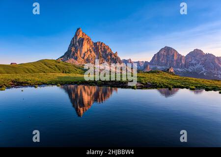 Mt. RA Gusela spiegelt sich in einem See auf dem Giau Pass, Passo di Giau, Tofana-Gruppe (rechts) in der Ferne, bei Sonnenaufgang. Stockfoto