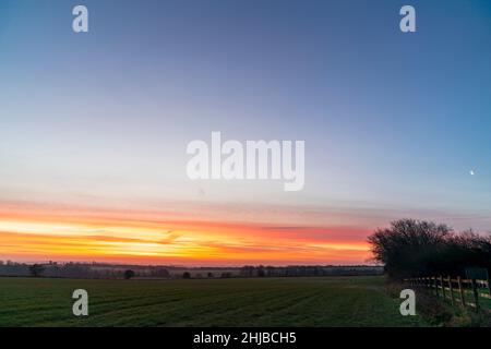 Reculver, Herne Bay, Kent, Großbritannien. 28th Januar 2022. Der Morgenhimmel über der Landschaft im Südosten von Kent liegt heute Morgen. Während bedeckter und düsterer Himmel versprochen wurde, gab es im Südosten eine willkommene Veränderung eines roten und gelben Himmels eine Stunde vor dem Sonnenaufgang mit klarem Himmel über dem Himmel. Quelle: Malcolm Fairman/Alamy Live News Stockfoto