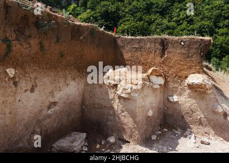 Archäologen gruben am Hang ein Loch, um nach historischen Artefakten und Funden zu suchen. Archäologische Arbeiten Stockfoto