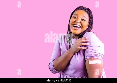 Menschen Gesundheits- und Schutzkonzept positive Frau bekommt Impfung und zeigt eine Hand mit Gips in rosa Studio Stockfoto