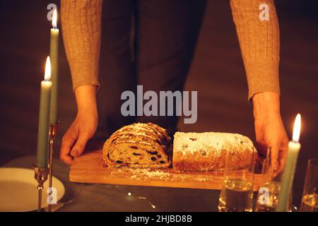 Selektiver Fokus der Frau, die köstliche frisch gebackene hausgemachte xms-Torte mit Messer hält, um Heiligabend oder Neujahr mit Freunden oder Familie zu feiern Stockfoto