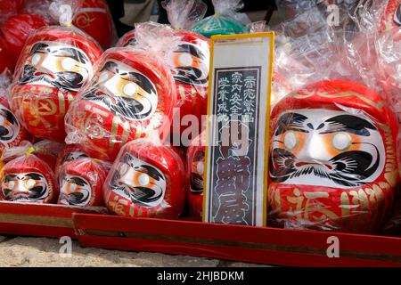 Hino, Tokio, Japan. 28th Januar 2022. Japanische Daruma-Puppen sind im Takahata Fudoson Tempel in Hino City zu sehen. Etwa 150 Verkäufer versammeln sich, um Daruma-Puppen ohne auf ihre Augen gemalte Schüler für Menschen zu verkaufen, die im Laufe des Jahres Glück suchen. Menschen färben sich in einer Pupille, wenn ein Wunsch oder ein Ziel gesetzt wird, und wenn der Wunsch wahr wird oder das Ziel erreicht wird, füllen sie die andere Pupille aus. Am Ende des Jahres werden gebrauchte Daruma-Puppen wieder in den Tempel zurückgebracht, um dort verbrannt zu werden. (Bild: © Rodrigo Reyes Marin/ZUMA Press Wire) Stockfoto