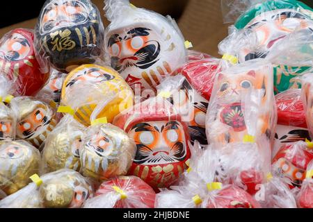 Hino, Tokio, Japan. 28th Januar 2022. Japanische Daruma-Puppen sind im Takahata Fudoson Tempel in Hino City zu sehen. Etwa 150 Verkäufer versammeln sich, um Daruma-Puppen ohne auf ihre Augen gemalte Schüler für Menschen zu verkaufen, die im Laufe des Jahres Glück suchen. Menschen färben sich in einer Pupille, wenn ein Wunsch oder ein Ziel gesetzt wird, und wenn der Wunsch wahr wird oder das Ziel erreicht wird, füllen sie die andere Pupille aus. Am Ende des Jahres werden gebrauchte Daruma-Puppen wieder in den Tempel zurückgebracht, um dort verbrannt zu werden. (Bild: © Rodrigo Reyes Marin/ZUMA Press Wire) Stockfoto