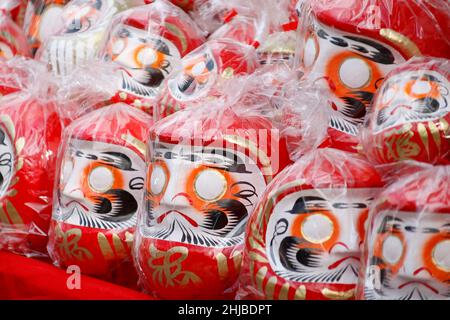 Hino, Tokio, Japan. 28th Januar 2022. Japanische Daruma-Puppen sind im Takahata Fudoson Tempel in Hino City zu sehen. Etwa 150 Verkäufer versammeln sich, um Daruma-Puppen ohne auf ihre Augen gemalte Schüler für Menschen zu verkaufen, die im Laufe des Jahres Glück suchen. Menschen färben sich in einer Pupille, wenn ein Wunsch oder ein Ziel gesetzt wird, und wenn der Wunsch wahr wird oder das Ziel erreicht wird, füllen sie die andere Pupille aus. Am Ende des Jahres werden gebrauchte Daruma-Puppen wieder in den Tempel zurückgebracht, um dort verbrannt zu werden. (Bild: © Rodrigo Reyes Marin/ZUMA Press Wire) Stockfoto