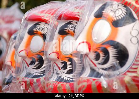 Hino, Tokio, Japan. 28th Januar 2022. Japanische Daruma-Puppen sind im Takahata Fudoson Tempel in Hino City zu sehen. Etwa 150 Verkäufer versammeln sich, um Daruma-Puppen ohne auf ihre Augen gemalte Schüler für Menschen zu verkaufen, die im Laufe des Jahres Glück suchen. Menschen färben sich in einer Pupille, wenn ein Wunsch oder ein Ziel gesetzt wird, und wenn der Wunsch wahr wird oder das Ziel erreicht wird, füllen sie die andere Pupille aus. Am Ende des Jahres werden gebrauchte Daruma-Puppen wieder in den Tempel zurückgebracht, um dort verbrannt zu werden. (Bild: © Rodrigo Reyes Marin/ZUMA Press Wire) Stockfoto