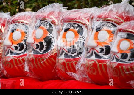 Hino, Tokio, Japan. 28th Januar 2022. Japanische Daruma-Puppen sind im Takahata Fudoson Tempel in Hino City zu sehen. Etwa 150 Verkäufer versammeln sich, um Daruma-Puppen ohne auf ihre Augen gemalte Schüler für Menschen zu verkaufen, die im Laufe des Jahres Glück suchen. Menschen färben sich in einer Pupille, wenn ein Wunsch oder ein Ziel gesetzt wird, und wenn der Wunsch wahr wird oder das Ziel erreicht wird, füllen sie die andere Pupille aus. Am Ende des Jahres werden gebrauchte Daruma-Puppen wieder in den Tempel zurückgebracht, um dort verbrannt zu werden. (Bild: © Rodrigo Reyes Marin/ZUMA Press Wire) Stockfoto