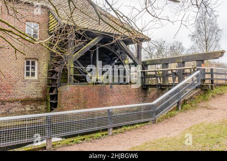 Rad der Wassermühle Leumolen oder Sint-Ursulamolen am Leubeek, Wehr, Metallzaun, Ziegelmauern, Äste. Leudal Naturschutzgebiet auf einer cl Stockfoto