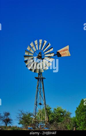 Traditionelle Windmühle zum Pumpen von Wasser im Outback von Südaustralien vor einem klaren blauen Himmel Stockfoto