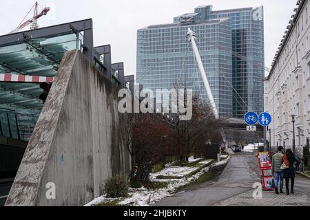 Ein Paar geht auf einem Fußweg neben dem Eingang zum Petuel-Tunnel. Um die Schlagzeile einer Zeitung in einer Verkaufsbox zu lesen: Wie Corona uns verändert hat. Stockfoto