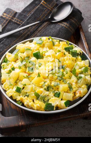 Zarangollo ist ein traditionelles spanisches Eiergericht aus Murcia, das aus Rühreiern, Zwiebeln und Zucchinis in der Nähe auf dem Teller auf dem Tisch zubereitet wird Stockfoto