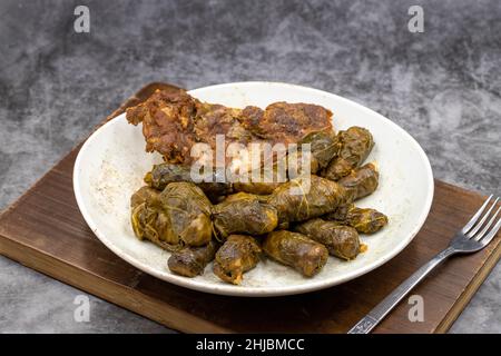 Fleischblatt-Verpackung. Traditionell mediterraner Geschmack. Einpackend Blätter auf einem dunklen Hintergrund. Lokaler Name etli yaprak sarma Stockfoto