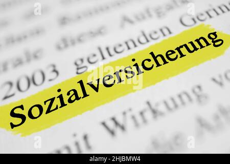 Eine Nahaufnahme des hervorgehobenen deutschen Wortes „Sozialversicherung“ in einer Zeitung Stockfoto