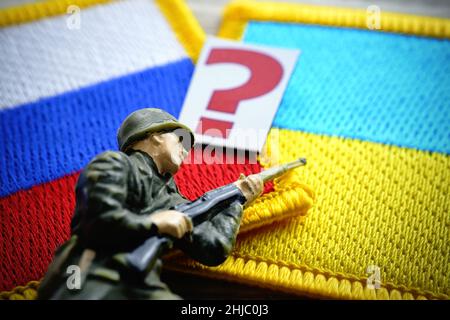Soldatenfigur und Fragezeichen auf Fahnen von Russland und der Ukraine, Ukraine-Krise Stockfoto