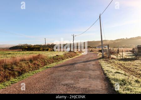 Blick auf die typische Alentejo-Landschaft mit portugiesischem Dorf im Morgennebel und aufgehender Sonne auf dem Wanderweg Rota Vicentina in der Nähe von Carrascalinhino, Aljezur Stockfoto