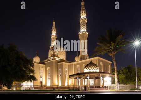 Jumeirah Moschee in Dubai, Vereinigte Arabische Emirate im traditionellen fatimidischen Stil, nachts beleuchtet. Stockfoto