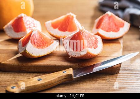 In Scheiben geschnittene Zitrusfrüchte. Gehackte frische Grapefruit auf einem Schneidebrett. Stockfoto