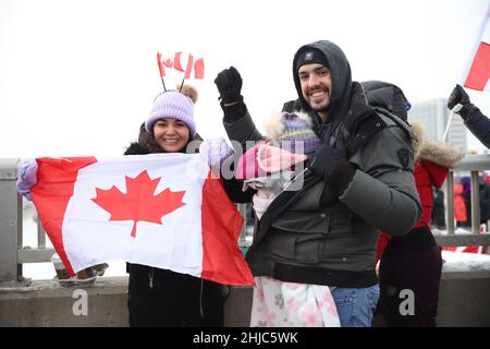 Toronto, Kanada. 27th Januar 2022. Demonstranten und Unterstützer gegen ein COVID-19-Impfmandat für grenzüberschreitende Lkw-Fahrer jubeln an, als am Donnerstag, den 27. Januar 2022, eine Parade von Lastwagen und Fahrzeugen vor Toronto, Ontario, Canda, vorbeizieht. (Foto: Jeremy Sandler/imageSPACE/Sipa USA) Quelle: SIPA USA/Alamy Live News Stockfoto