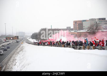 Toronto, Kanada. 27th Januar 2022. Demonstranten und Unterstützer gegen ein COVID-19-Impfmandat für grenzüberschreitende Lkw-Fahrer jubeln an, als am Donnerstag, den 27. Januar 2022, eine Parade von Lastwagen und Fahrzeugen vor Toronto, Ontario, Canda, vorbeizieht. (Foto: Jeremy Sandler/imageSPACE/Sipa USA) Quelle: SIPA USA/Alamy Live News Stockfoto