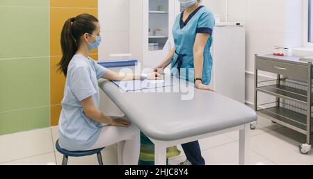 Ein Arzt wickelte sich um das Handgelenk, um die erste-Hilfe-Nahaufnahme zu machen. Anwendung von Verbänden auf die Hände des Patienten, erste-Hilfe-Konzepte und Verletzungen des Handgelenks Stockfoto