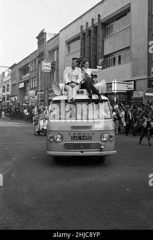 Bristol University Rag 1968: Radio 1 DJ Ed Stewart und die 1968 Rag Queen müssen auf das Dach des W D und H O Wills Kommentars-Van greifen, nachdem ihr alter Rolls Royce, der die Rag-Prozession 1968 führte, mechanische Probleme entwickelt hat. Die Parade ging am Samstag, dem 9. März 1968, vom Parkplatz der Clifton Down Station aus los und erreichte das Stadtzentrum, nachdem sie die Victoria Rooms und das Wills Memorial Building passiert hatte. Danach ging es die Park Street entlang und um das Zentrum herum, bevor sie zu den Victoria Rooms zurückkehrte. Tausende von Zuschauern säumten die Straßen und Tausende von Pfund wurden gesammelt. Stockfoto