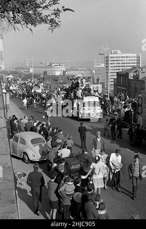 Bristol University Rag 1968: Die Wagen der Rag-Prozession 1968 ziehen sich langsam entlang der Park Row, während sie in die Victoria Rooms und das Ende der Parade-Route auffahren. Angeführt von Radio 1 DJ Ed Stewart und der 1968 Rag Queen, waren die Wagen am Samstag, dem 9. März, vom Parkplatz der Clifton Down Station aus los, vorbei an den Victoria Rooms und Wills Memorial Building, dann entlang der Park Street und um das Stadtzentrum herum. Tausende von Zuschauern säumten die Straßen und Tausende von Pfund wurden für wohltätige Zwecke aus den Pennies, sechzig und halben Kronen, die in Sammeldosen gesteckt wurden, gesammelt. Stockfoto