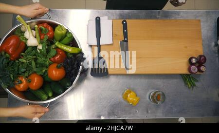 Frisches Rohes Frühlingsgemüse. Clip. Essen Vegetarisch Hintergrund. Tomaten, Gurke, Radieschen, Salatblätter im Metallkorb. Draufsicht Stockfoto
