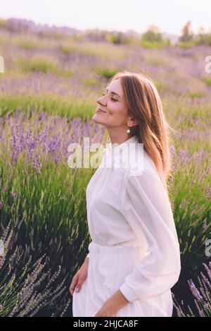 Mädchen in Weiß auf dem blühenden Lavendelfeld Stockfoto