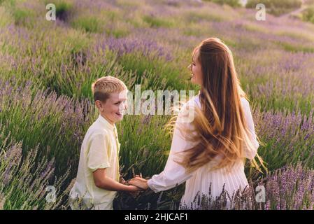 Mutter und Sohn umarmen sich am Lavendelfeld Stockfoto