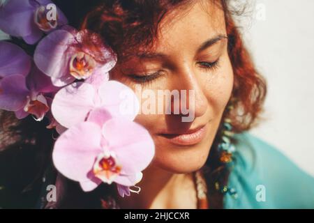 Junge Frau riecht eine schöne Blüte. Frühlingszauber. Stockfoto