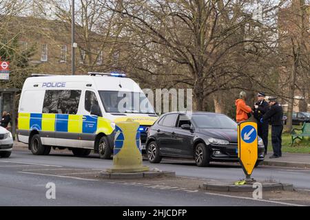 London Greenwich, Großbritannien. 28th Januar 2022. Ein Fahrer in einem schwarzen Auto wurde angehalten und schien von uniformierten Polizeibeamten in der Nähe des Dorfes Blackheath im Südosten Londons, England, durchsucht zu werden. Quelle: xiu bao/Alamy Live News Stockfoto