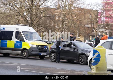 London Greenwich, Großbritannien. 28th Januar 2022. Ein Fahrer in einem schwarzen Auto wurde angehalten und schien von uniformierten Polizeibeamten in der Nähe des Dorfes Blackheath im Südosten Londons, England, durchsucht zu werden. Quelle: xiu bao/Alamy Live News Stockfoto