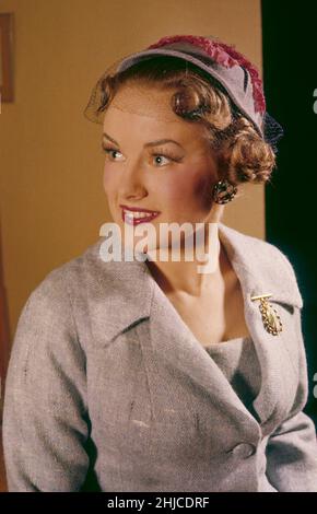 Modisch im 1950s. Eine junge Frau in einer grauen Jacke und einem Hut. Eine typische Mode der 1950s, die das gut gekleidete Jahrzehnt war. Schweden 1950s Ref. CV26-10 Stockfoto