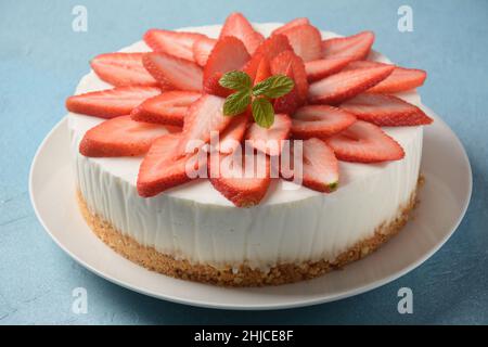 Weißkäsekuchen mit Erdbeeren, garniert mit Minze Stockfoto