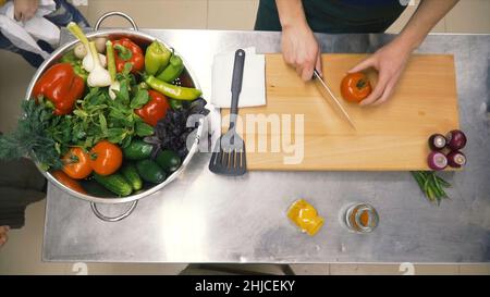 Frisches Rohes Frühlingsgemüse. Clip. Essen Vegetarisch Hintergrund. Tomaten, Gurke, Radieschen, Salatblätter im Metallkorb. Draufsicht Stockfoto