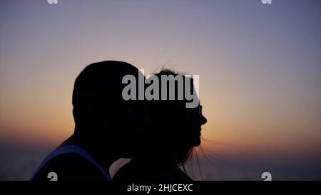 Nahaufnahme der Silhouette eines jungen Paares beim Sonnenuntergang in einem Park. Lager. Romantische junge Paar Silhouette. Stockfoto