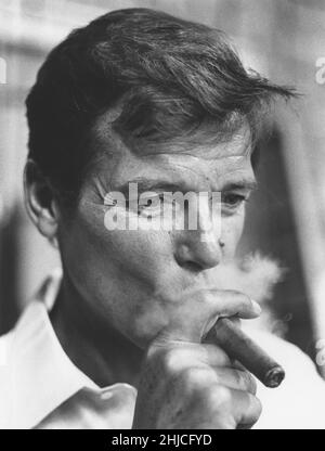 Sir Roger Moore , 1927-2017 berühmter Filmstar in Rollen als der Heilige Simon Templer und James Bond. Hier im Bild eine Zigarre rauchen im Jahre 1970s. Stockfoto