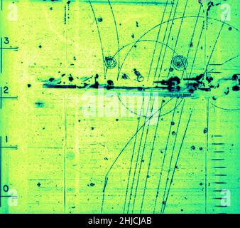 Blasenkammer-Ereignis: Partikel, die durch die Bleiabschirmung gelangen. 17. November 1964. Blasenkammer-1408. Bleiabschirmung bezeichnet die Verwendung von Blei als eine Form des Strahlenschutzes, um Personen oder Objekte vor Strahlung zu schützen, um die effektive Dosis zu reduzieren. Blei kann aufgrund seiner hohen Dichte und der hohen Ordnungszahl bestimmte Arten von Strahlung effektiv dämpfen; im Prinzip ist es effektiv beim Stoppen von Gammastrahlen und Röntgenstrahlen. Eine Blasenkammer ist ein Gefäß, das mit einer überhitzten, transparenten Flüssigkeit (meist flüssigem Wasserstoff) gefüllt ist, mit der elektrisch geladene Partikel erfasst werden, die sich durch sie bewegen. Stockfoto