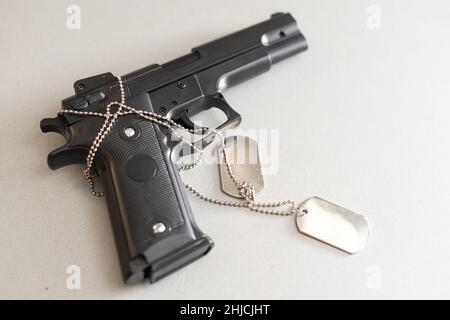 Pistole mit Dogtags. Konzept von Dienst und Dienst in US-Streitkräfte. Veteranenkonzept Stockfoto