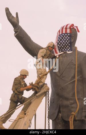 Bagdad, Irak; 9. April 2003. DIE US-Marineinfanteristen binden eine Kette um den Hals einer Statue des irakischen Diktators Saddam Hussein, während sie sich darauf vorbereiten, sie von ihrem Sockel auf dem Firdos-Platz in Bagdad abzureißen. Die Statue -- die Höhe von etwa vier Männern -- war eines der Symbole von Saddams Herrschaft über den Irak. Stockfoto