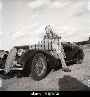 Damenmode im Jahr 1940s. Eine junge Frau in einem typischen Outfit von 1940s. Ein passender Rock und Jacke mit einem Leopardenmantel. Es handelt sich um einen italienischen Sportwagen des Automobilherstellers Alfa Romeo. Schweden 1946. Kristoffersson Ref. X1-3 Stockfoto