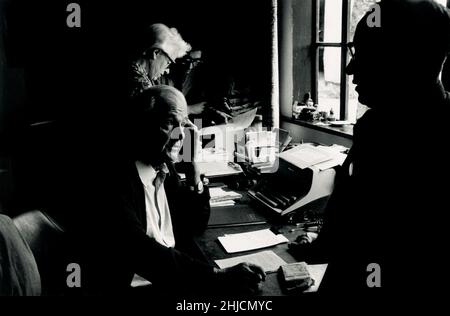 Sir Henry Spencer Moore spricht mit seinen Mitarbeitern in seinem Büro in seinem Haus in Much Hadham, 1970. Moore war ein in England geborener Künstler und Bildhauer, bekannt für seine modernistischen, abstrakten Werke. Geboren 1898, gestorben 1986. Stockfoto