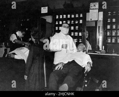 Ein Maskenbarbier während der Influenza 1918, auch bekannt als Spanische Grippe. Stockfoto