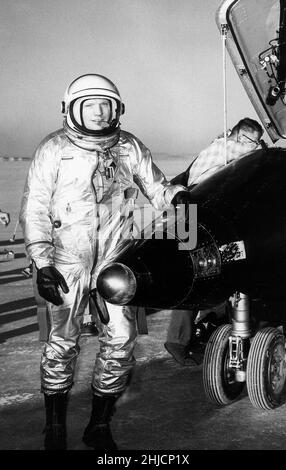 Der NASA-Testpilot Neil Armstrong ist hier neben dem X-15-Schiff #1 (56-6670) nach einem Forschungsflug zu sehen. Die X-15 war ein Raketenflugzeug, das 50 Fuß lang war und eine Flügelspannweite von 22 Fuß hatte. Es war ein raketenförmiges Fahrzeug mit einem ungewöhnlichen keilförmigen vertikalen Schwanz, dünnen, steigenartigen Flügeln und einzigartigen Seitenverkleidungen, die sich entlang der Seite des Rumpfes ausdehnten. Armstrong kommandierte später die Apollo 11-Mission und war die erste Person, die den Fuß auf den Mond stellte. Stockfoto