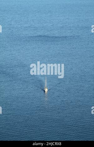 Ein einflüchigeres Segelboot in der tiefblauen Ägäis. Luftaufnahme. Stockfoto