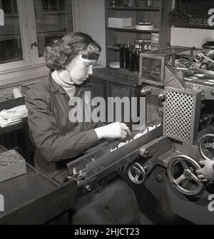 Herstellung von Briefmarken in der 1950s. Eine junge Frau bei den schwedischen Briefmarkendrucken der schwedischen Post an der Maschine, die Briefmarkenhefte herstellt. Schweden 1951 Kristoffersson Ref. bc46-8 Stockfoto