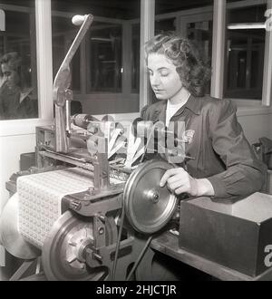 Herstellung von Briefmarken in der 1950s. Eine junge Frau bei den schwedischen Briefmarkendrucken der schwedischen Post an einer Maschine, die die Blätter fertig gedruckter Briefmarken in Rollen mit je 10 Marken zerteilt. Schweden 1951 Kristoffersson Ref. bc45-10 Stockfoto