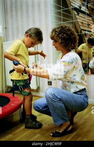 Archiv 90ies: Dr. Corinne Cristol nimmt mit einem behinderten Kind an einer funktionellen Umerziehungsveranstaltung Teil, Vaulx-en-Velin, Frankreich, 1991 Stockfoto